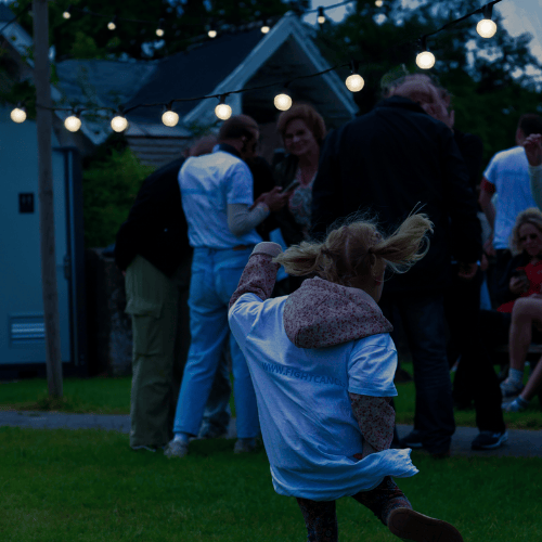 Dansend meisje met lampen slinger op achtergrond.