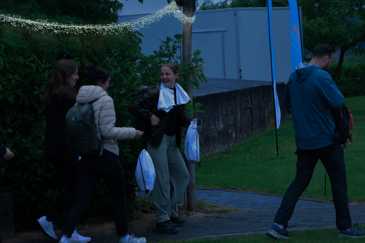 Drie lopende meiden in het donker met lichtslinger op de achtergrond.